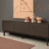 Un élégant buffet décoré devant un mur gris, partie de la collection Nolte Living.