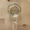 Ein Glas wird mit einem Seil zu einem hängenden Behälter gebunden.