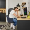 Ein Mann arbeitet in einer modernen Küche von Nolte Küchen am Schreibtisch mit einem Computer.