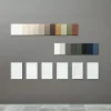 Farbmuster und Rahmen sind an einer grauen Wand ausgestellt, passend zu Nolte Living.