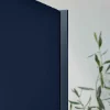 Eine blaue Schranktür mit einer Pflanze im Hintergrund, modernes Design von Nolte Küchen.
