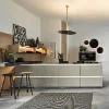 Eine moderne Küche mit Insel und Barhockern, dekoriert mit Pflanzen und Kunstwerken. Nolte Küchen.