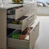 Eine moderne Küche mit geöffneten Schubladen und Kochinsel, präsentiert von Nolte Küchen.