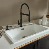 Eine moderne Küche mit weißem Spülbecken und schwarzer Armatur von Nolte Küchen.
