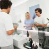 Ein Paar steht im modernen Badezimmer und faltet Handtücher, Spiegel im Hintergrund, Nolte SPA.