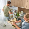 A modern kitchen with two people cooking; Nolte Kitchens.