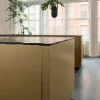 Eine moderne Küche mit großen Fenstern und einer goldenen Insel. Nolte Küchen.
