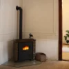 Una estufa de leña tradicional en una sala de estar con suelo de madera, Nolte Living.