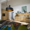 Eine moderne Küche mit Holzfronten und stilvoller Beleuchtung, im Vordergrund ein Esstisch. Nolte Küchen.