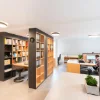 Ein modernes Büro mit Regalen und Schreibtischen, die eine organisierte Arbeitsumgebung schaffen.