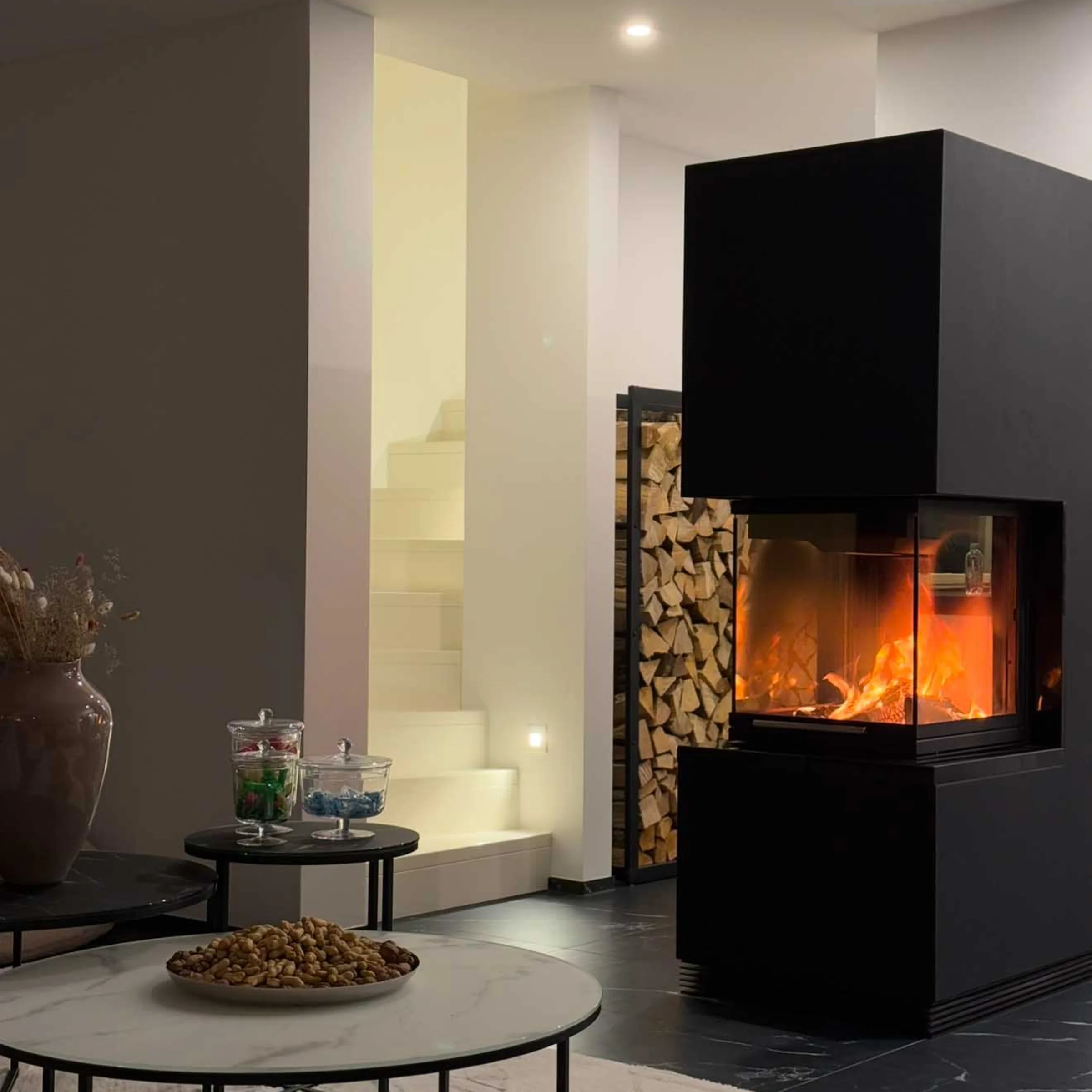 Ein modernes Wohnzimmer mit Kamin und dekorativen Elementen, passend zu Nolte Living.