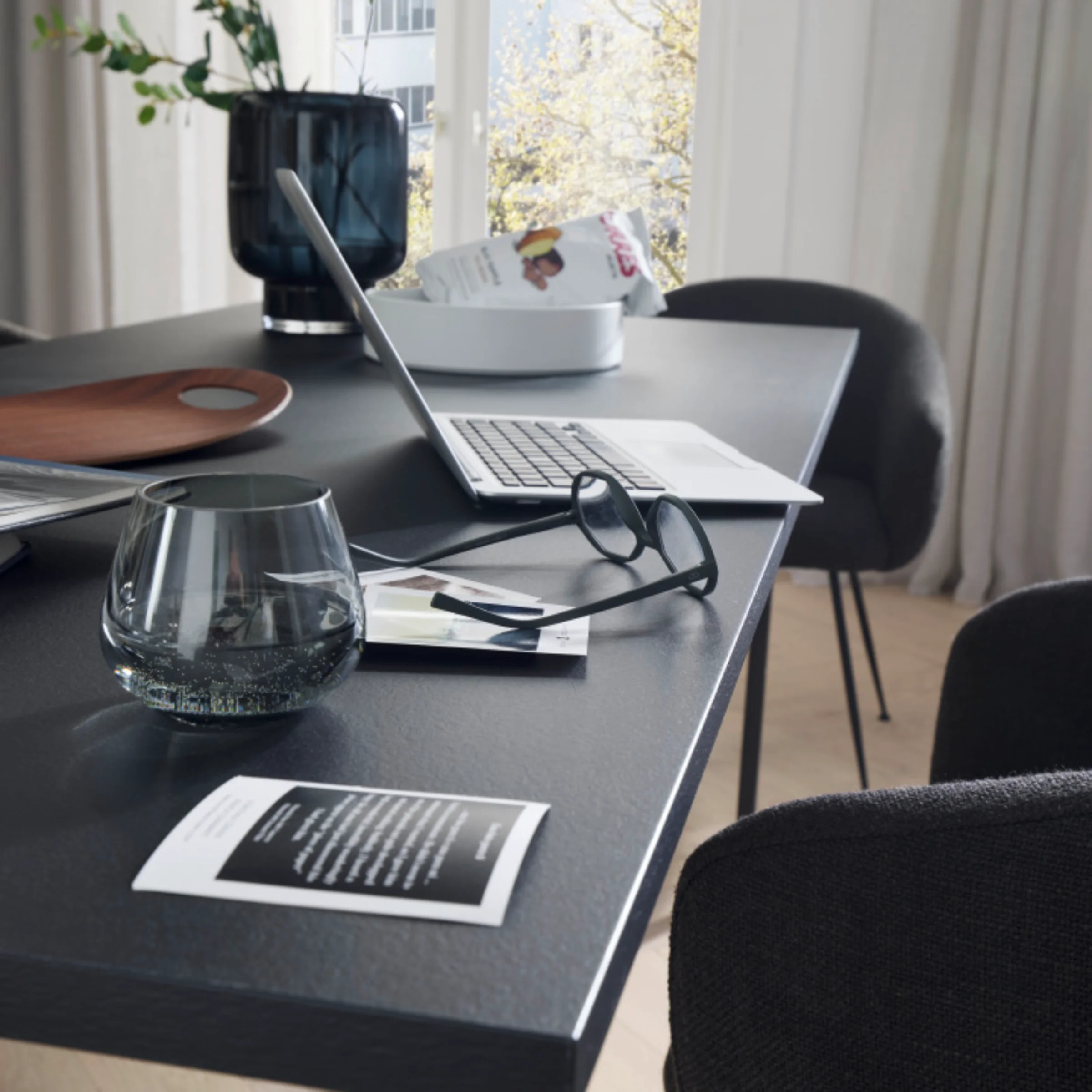 Ein moderner Wohnbereich mit Tisch, Laptop und Deko-Elementen, passend zu Nolte Living.