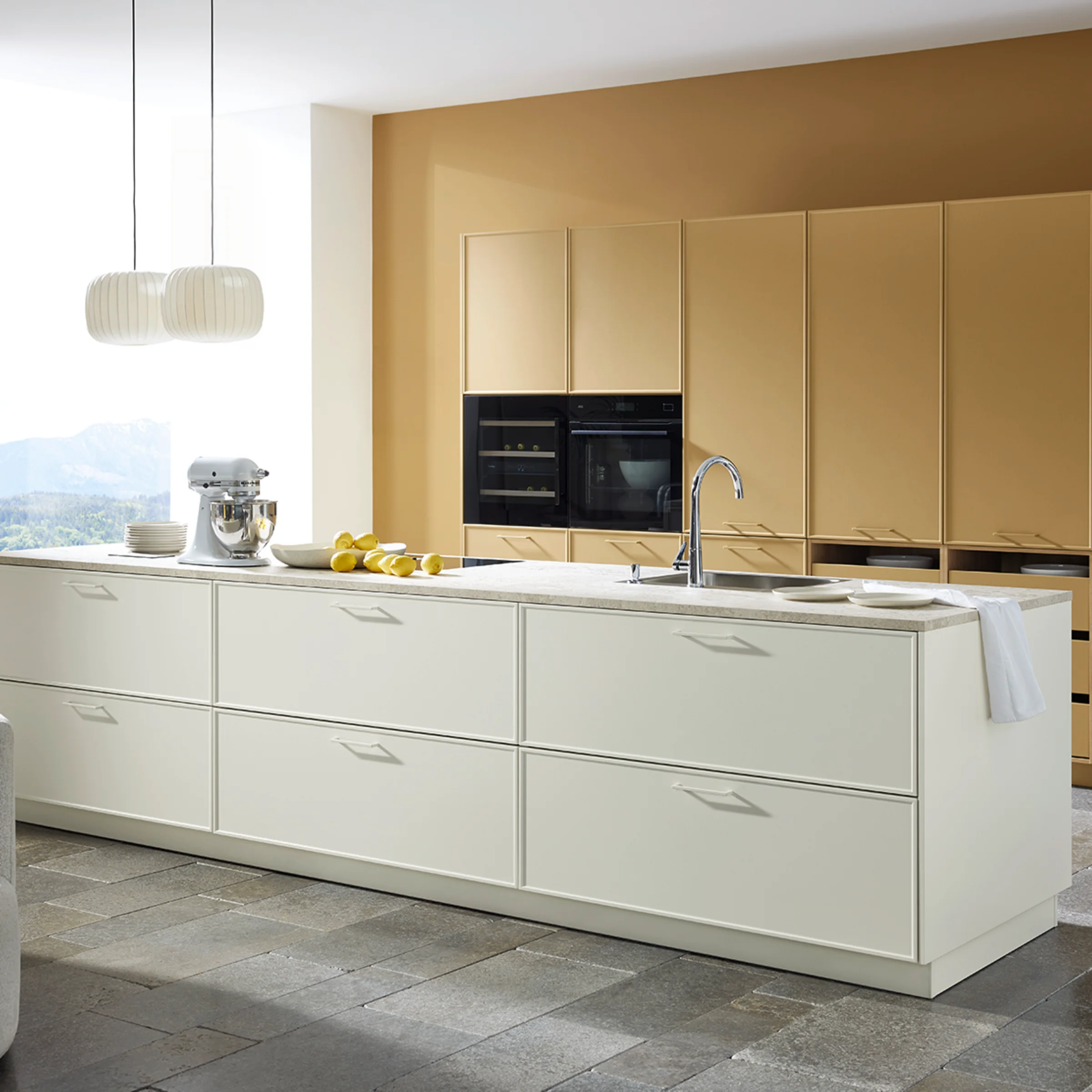 Eine moderne Küche mit Insel und beige Schränken. Nolte Küchen.