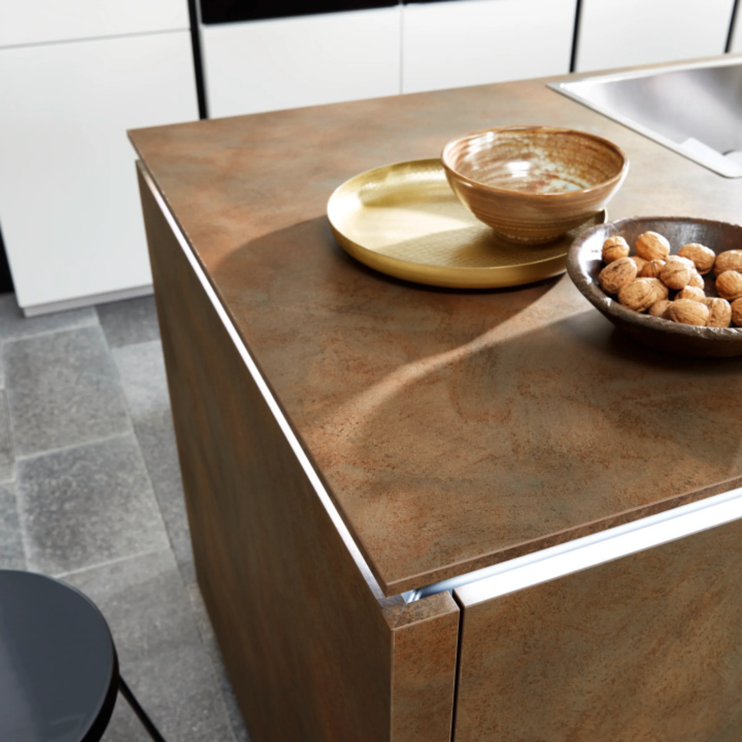 Eine moderne Küche mit Kochinsel aus Holzoptik und integriertem Waschbecken von Nolte Küchen.