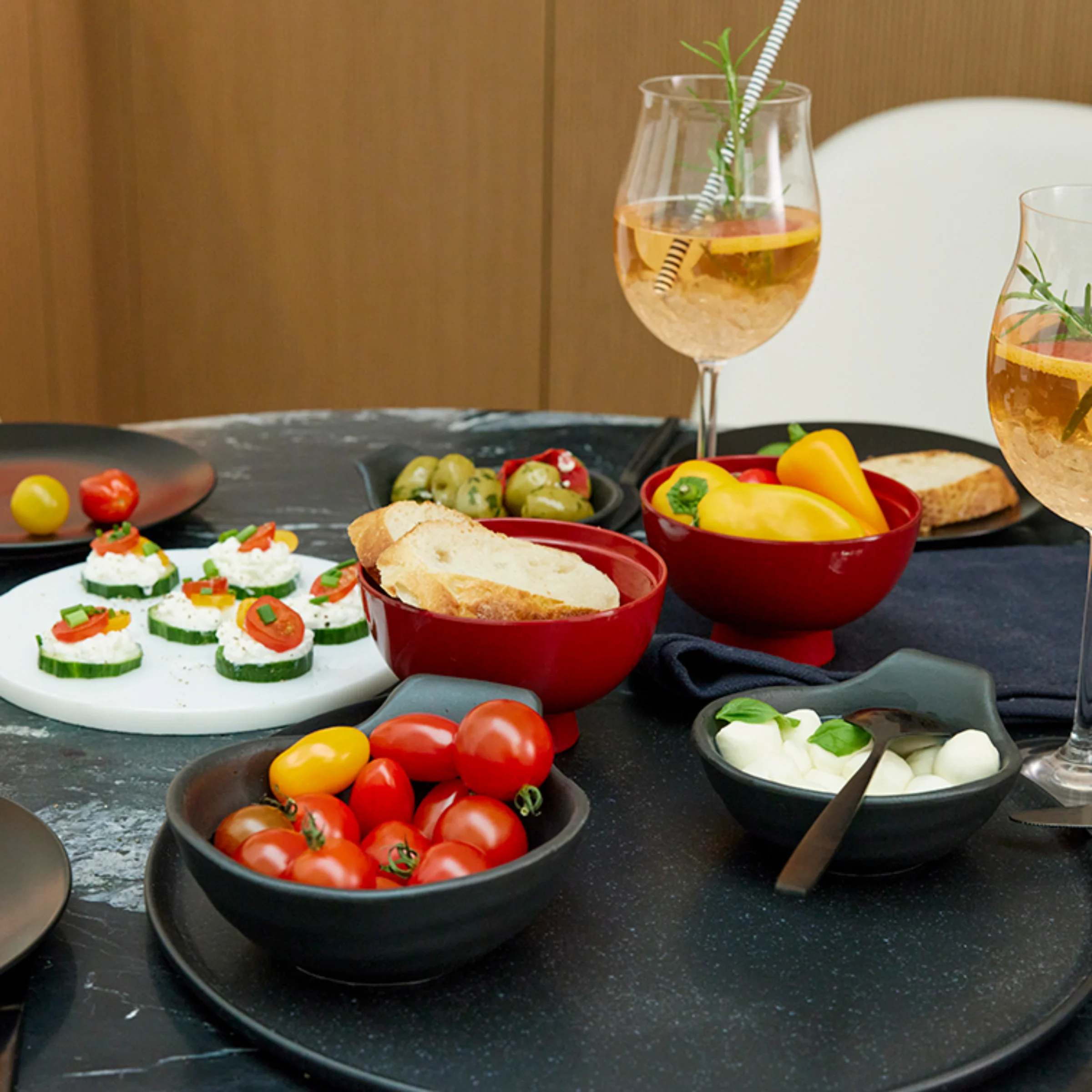 Ein stilvoll gedeckter Tisch mit Snacks und Getränken in einem modernen Ambiente von Nolte Küchen.