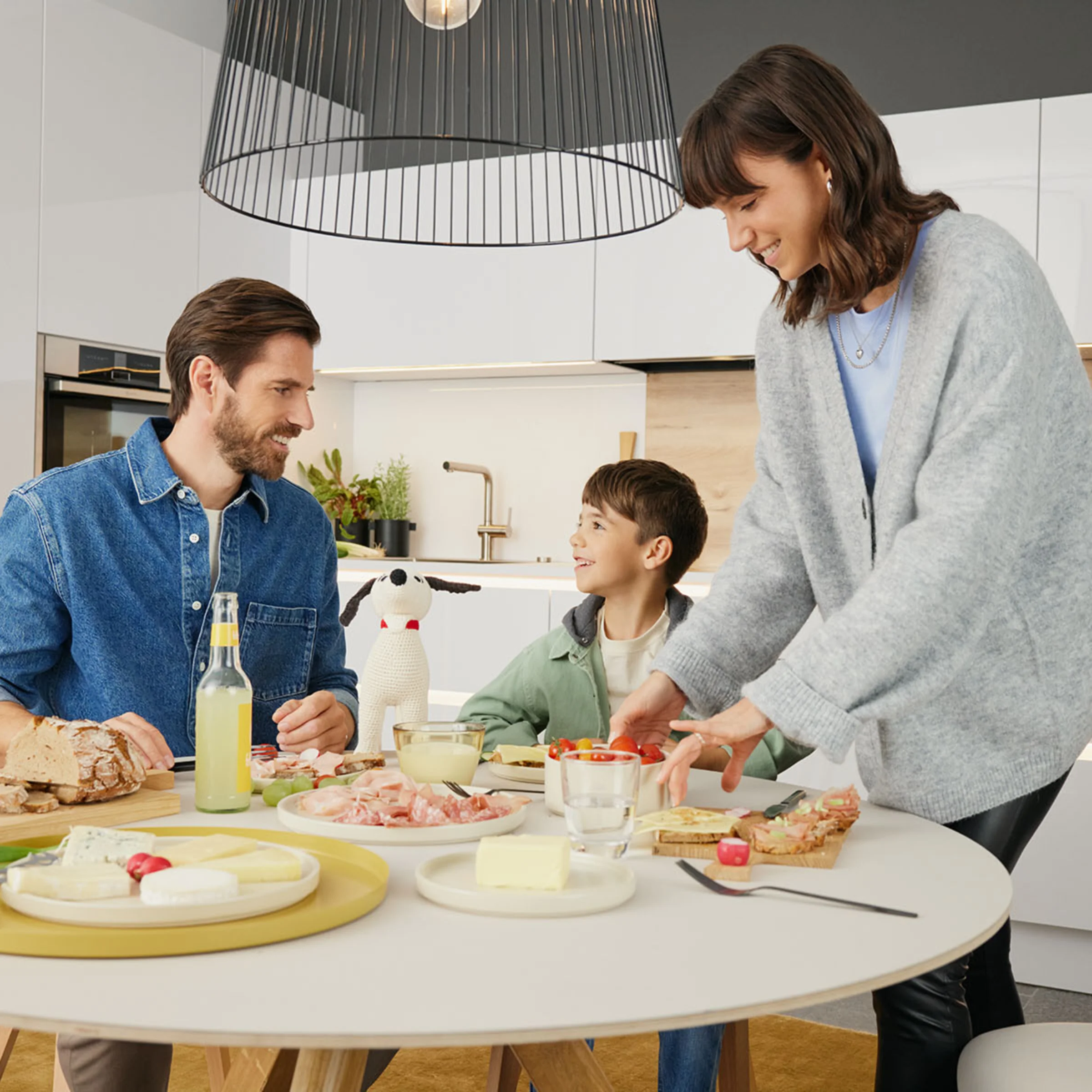 Eine Familie bereitet gemeinsam Frühstück in einer modernen Nolte Küchen Umgebung zu.