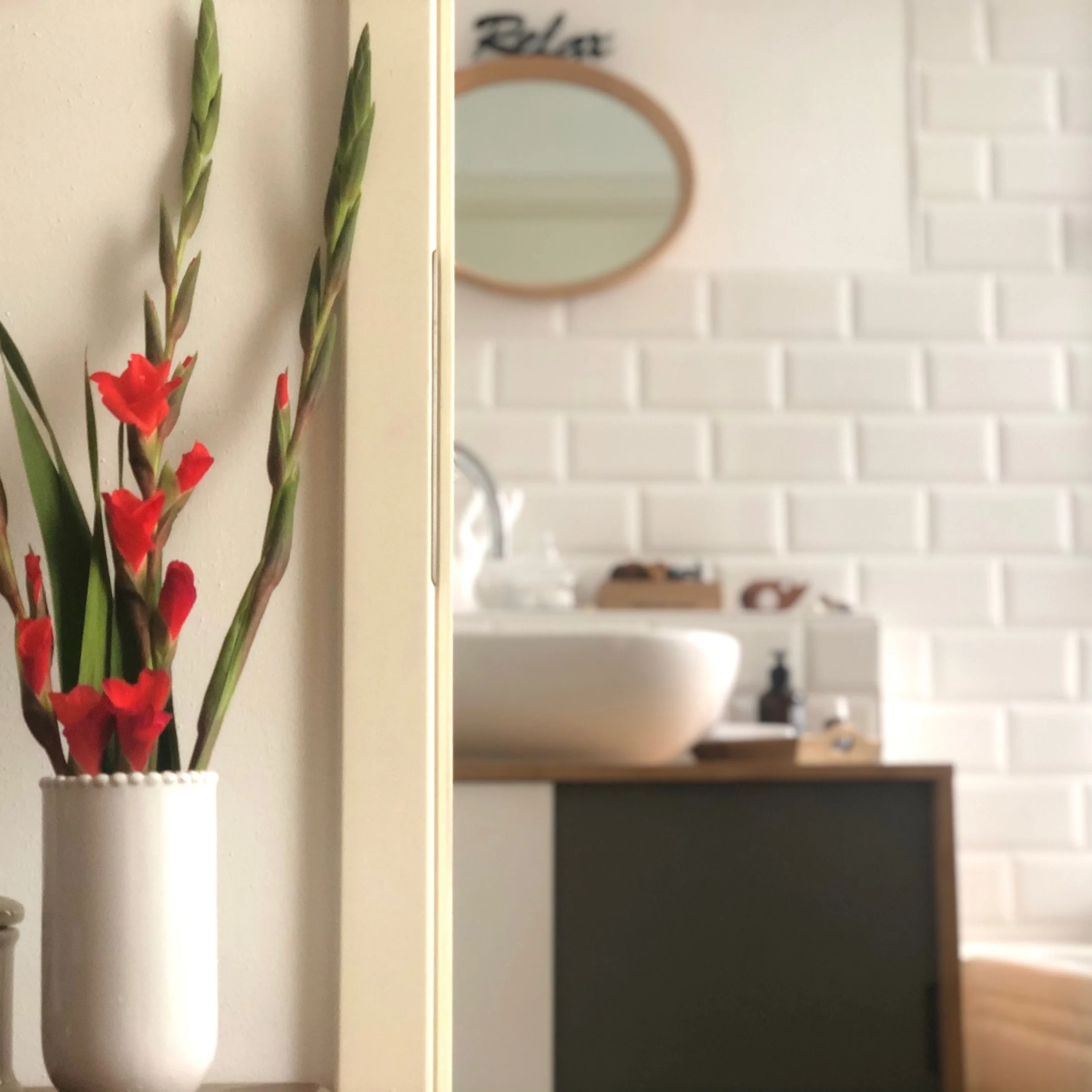 A modern bathroom with white tiles and decorative elements. Nolte Kitchen.