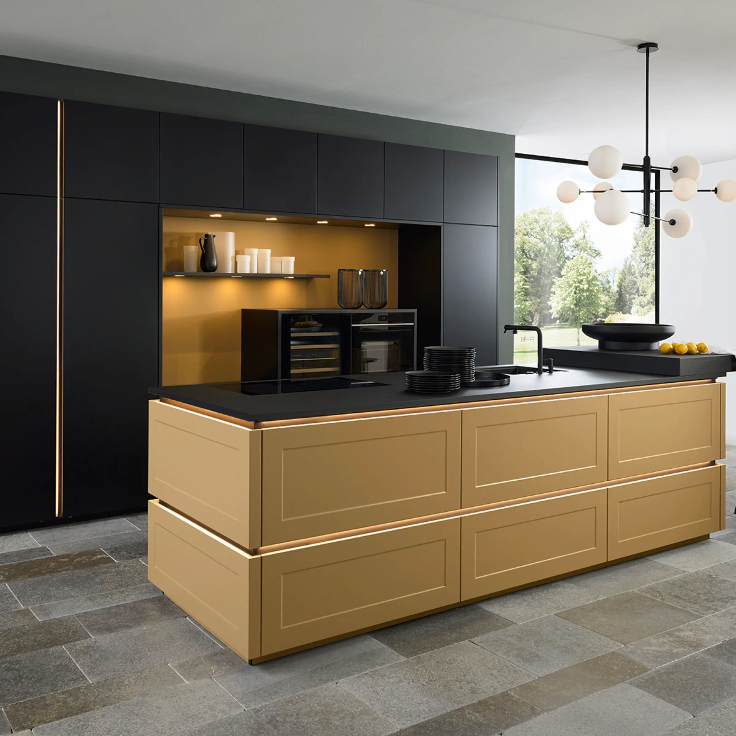 Eine moderne Küche mit goldener Insel und schwarzem Schrank, beleuchtet von einer Hängeleuchte. Nolte Küchen.
