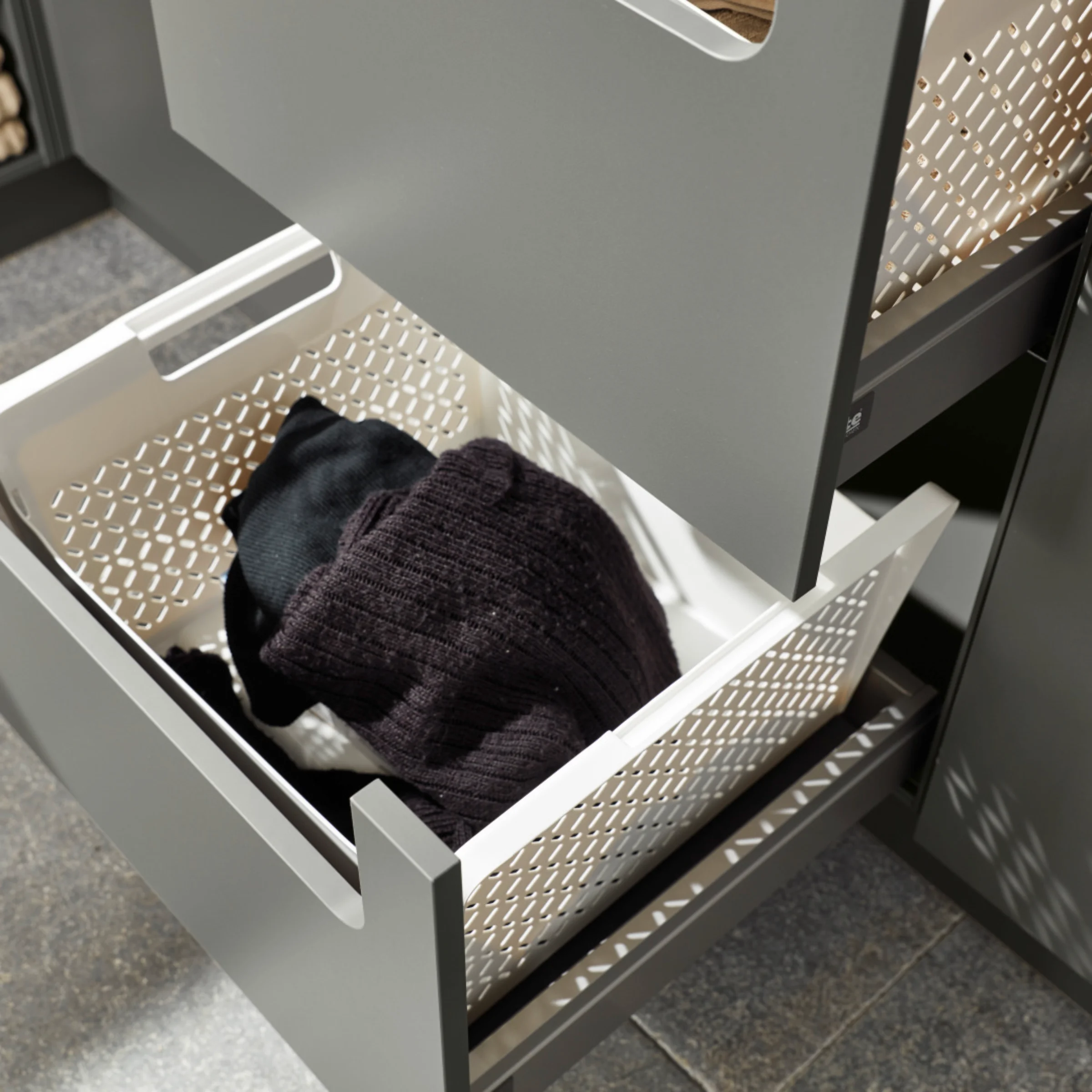 Een open ladekast met wasmanden in een bijkeuken van Nolte Utility Rooms.