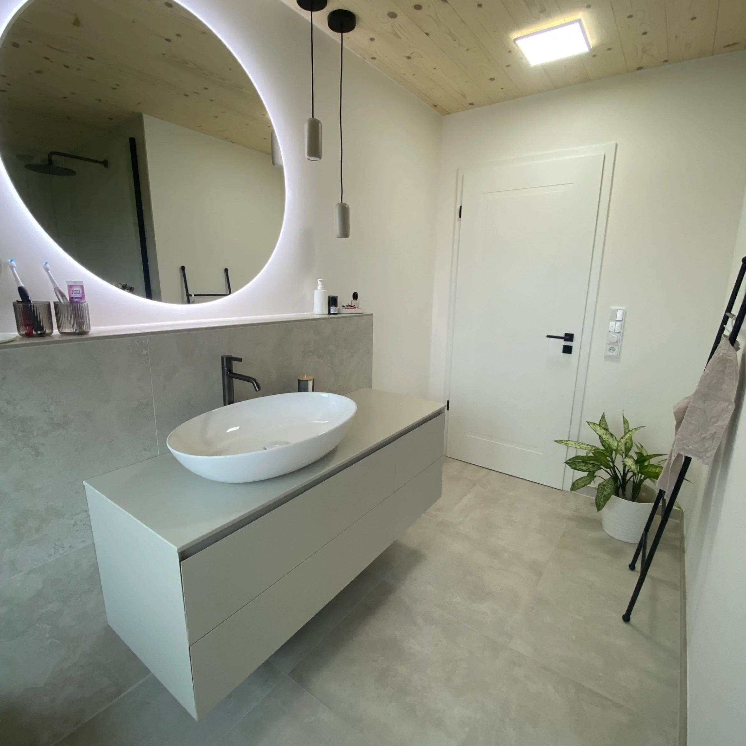 Ein modernes Badezimmer mit beleuchtetem Spiegel und Waschbecken. Nolte SPA.