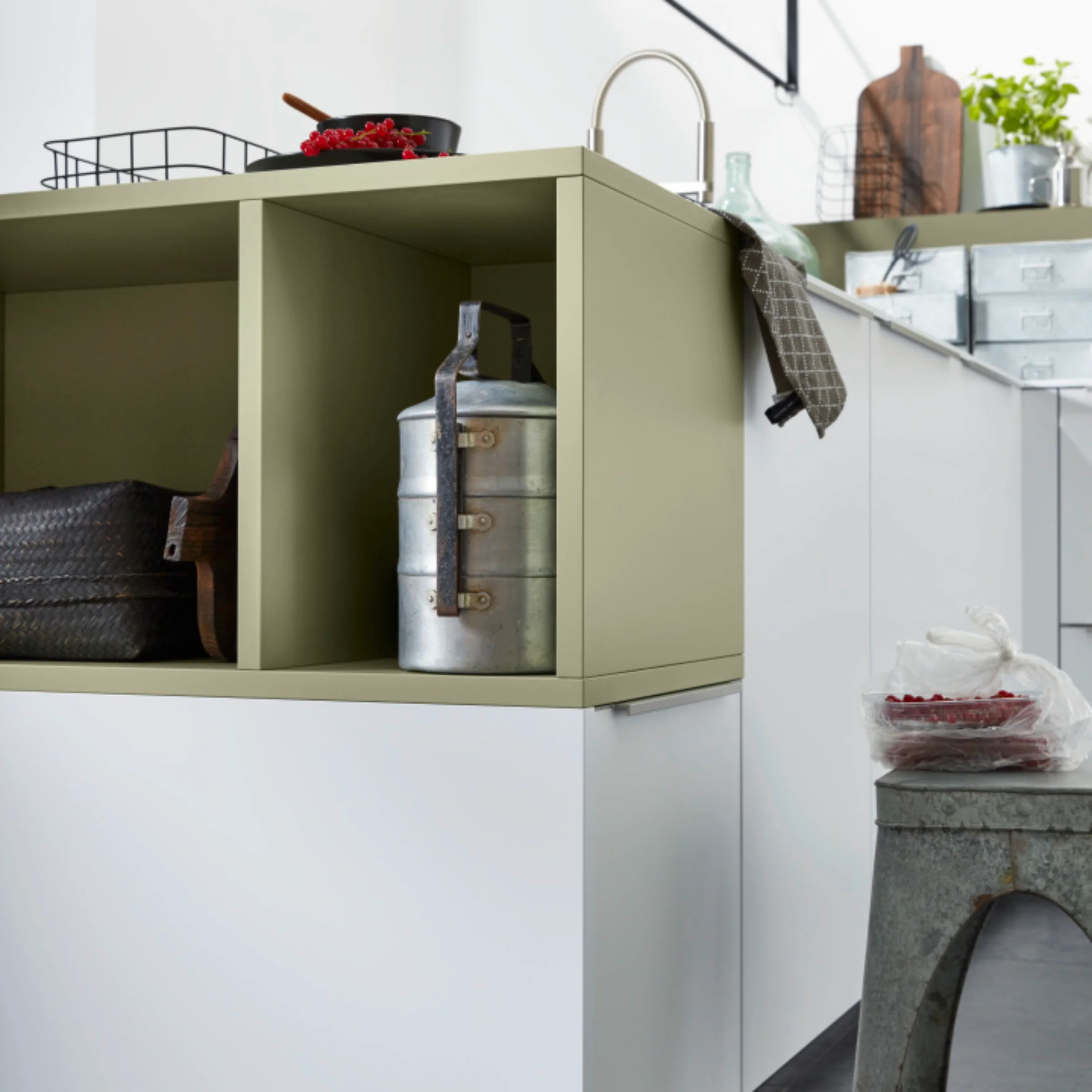 Eine moderne Küche mit weißen und olivgrünen Elementen von Nolte Küchen.