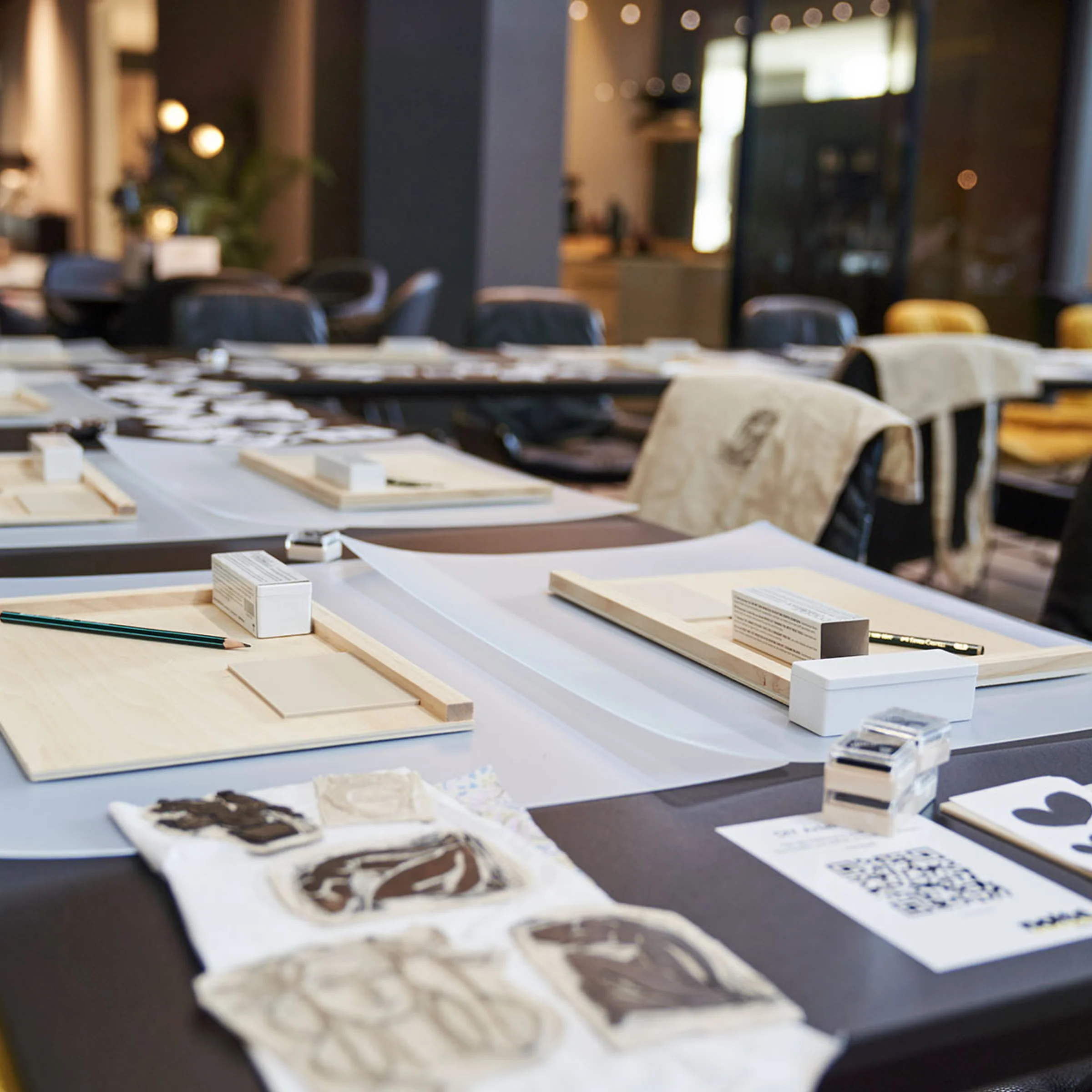In a stylish room, tables with creative materials and chairs are arranged, in the context of Nolte Living.