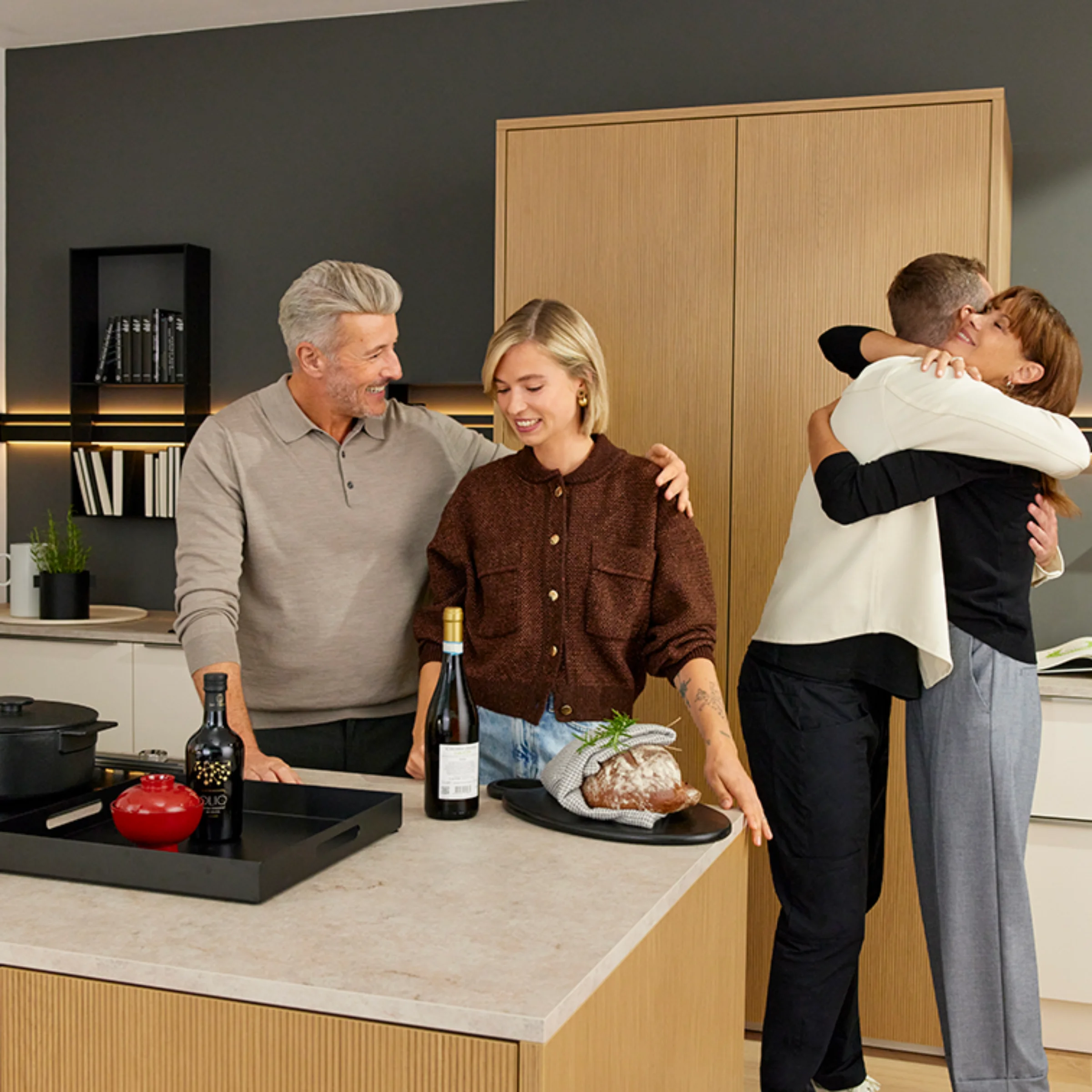 In einer modernen Küche von Nolte Küchen bereitet eine Gruppe von Menschen gemeinsam eine Mahlzeit zu.