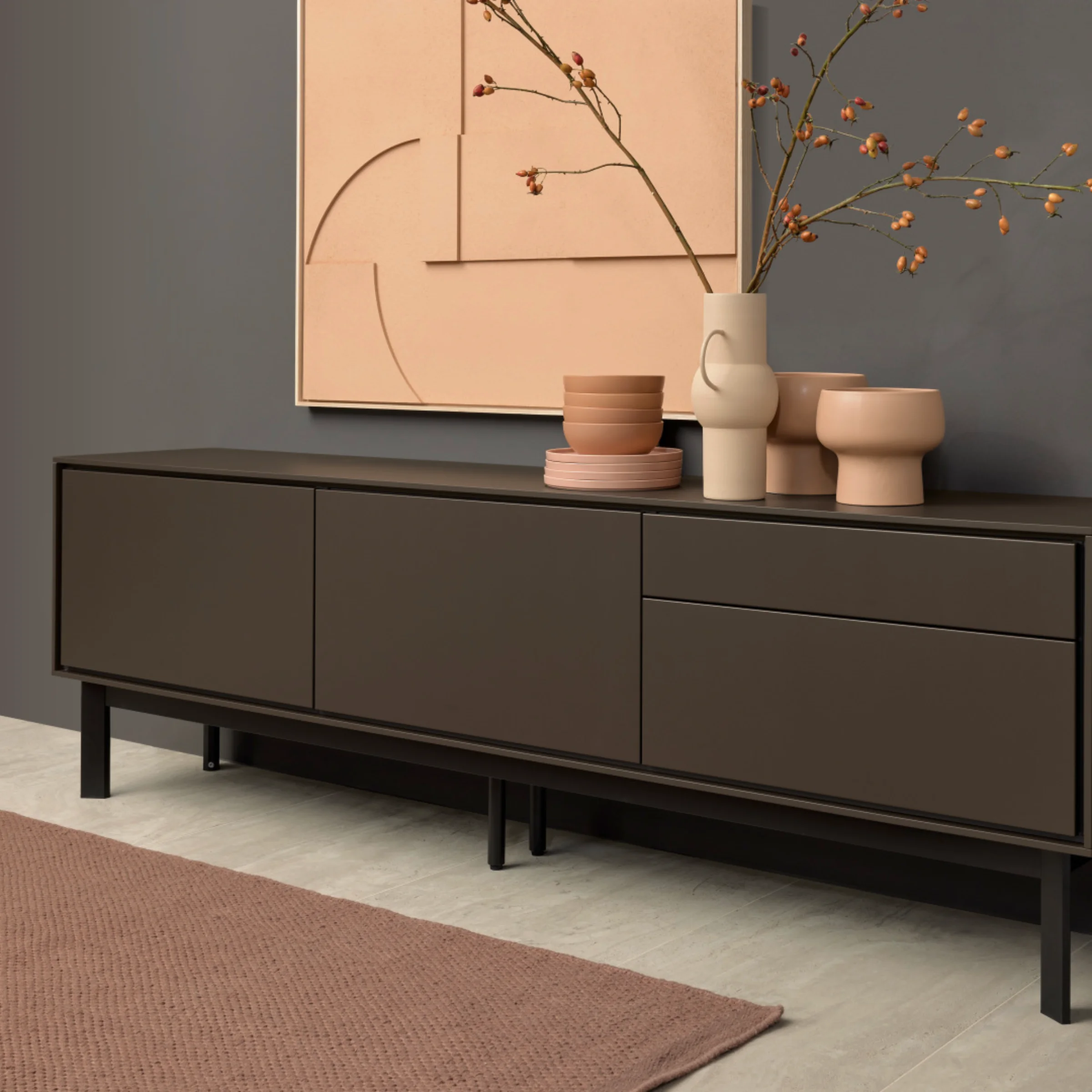 Un élégant buffet décoré devant un mur gris, partie de la collection Nolte Living.