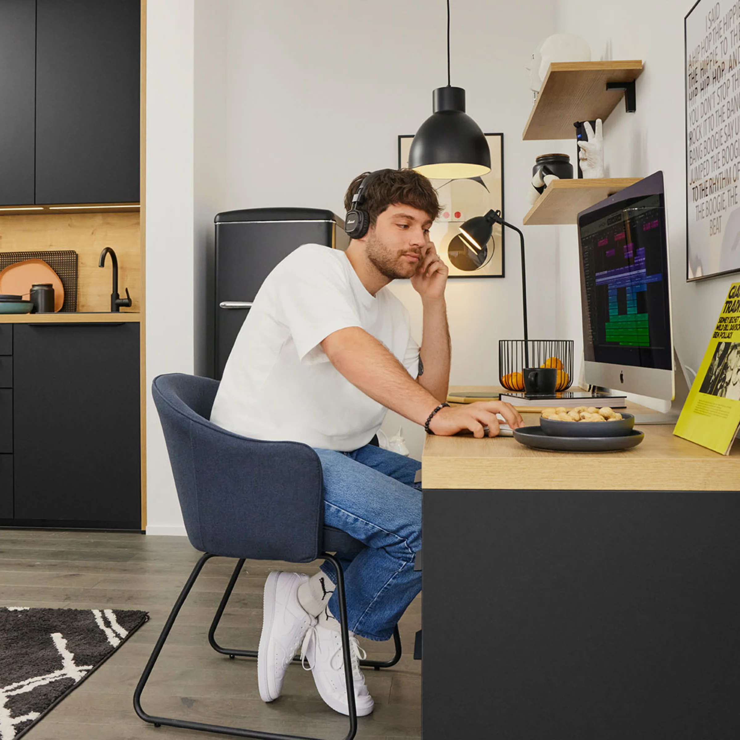 Ein Mann arbeitet in einer modernen Küche von Nolte Küchen am Schreibtisch mit einem Computer.
