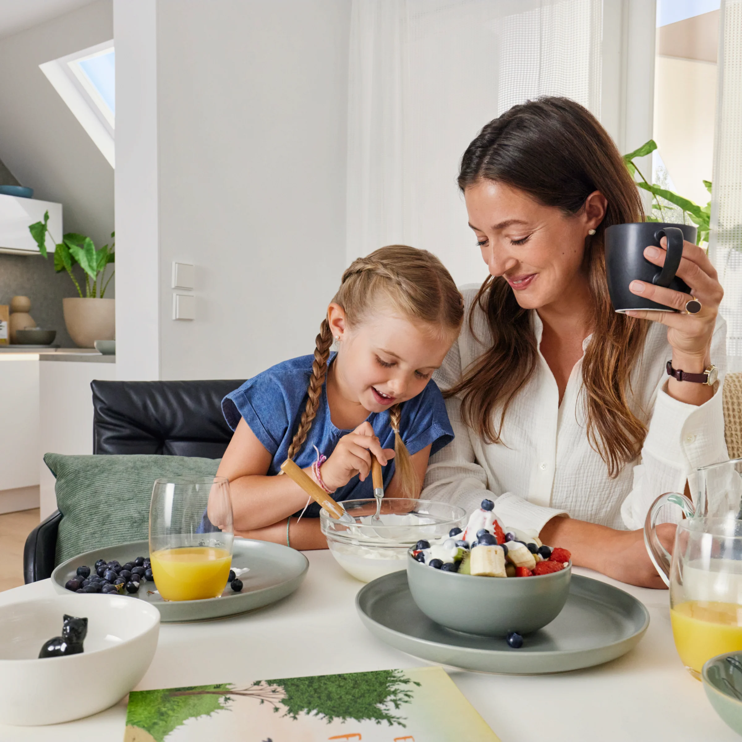 Eine Mutter und Tochter frühstücken gemeinsam in einer modernen Küche von Nolte Küchen.