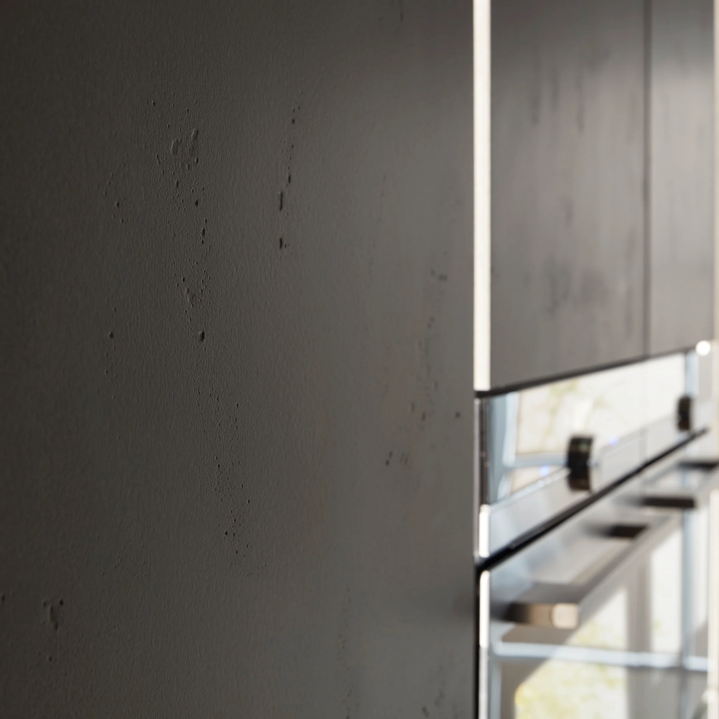 Eine moderne Küche mit dunklen Schränken und Edelstahlgeräten, gestaltet von Nolte Küchen.