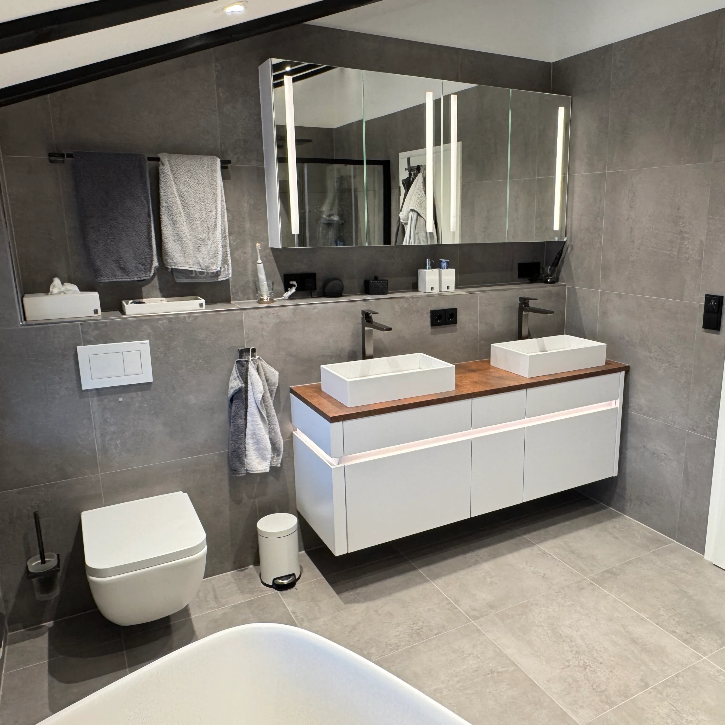 Ein modernes Badezimmer mit Doppelwaschbecken und Spiegel, gestaltet von Nolte SPA.