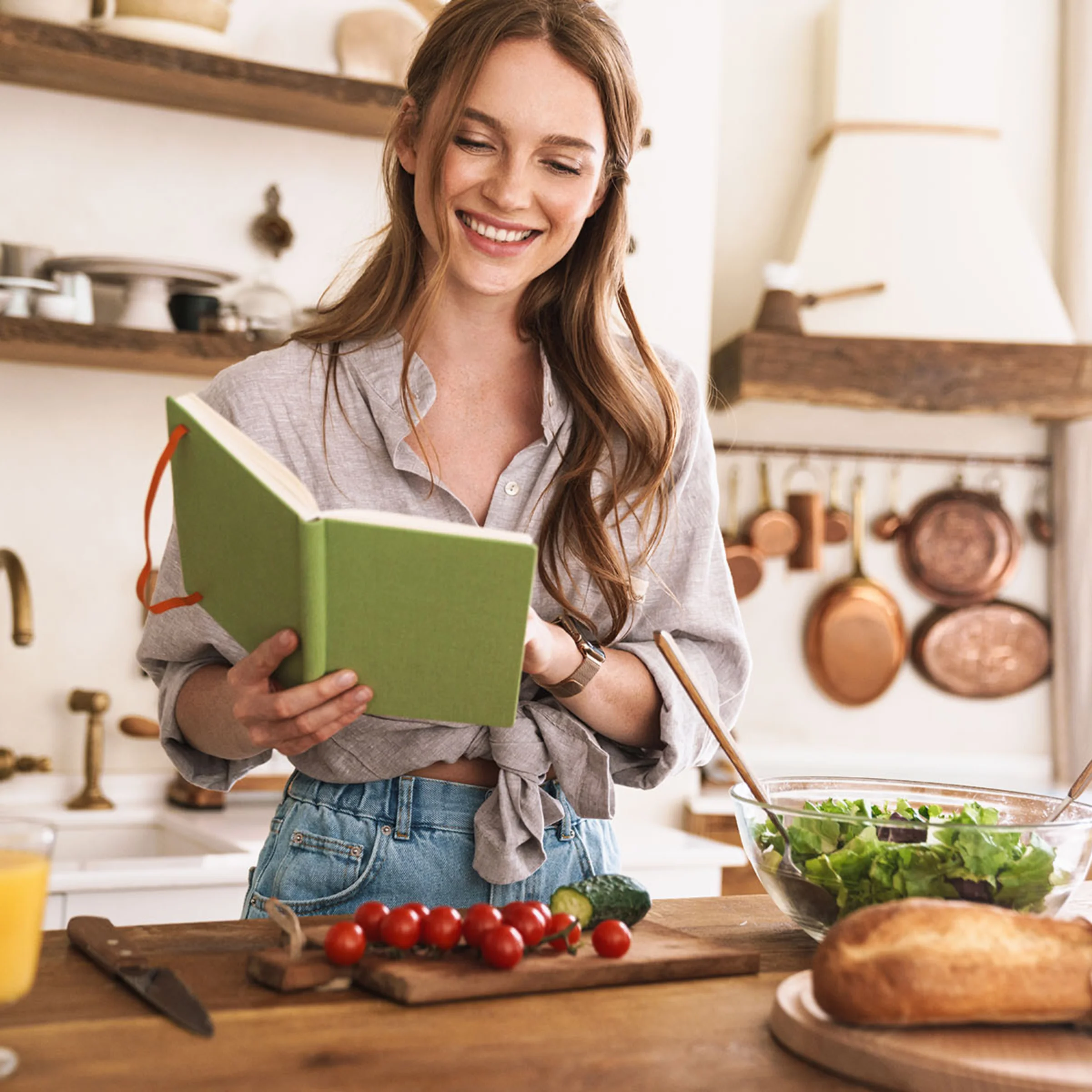 A woman cooking in a kitchen with fresh ingredients, Nolte Kitchen.