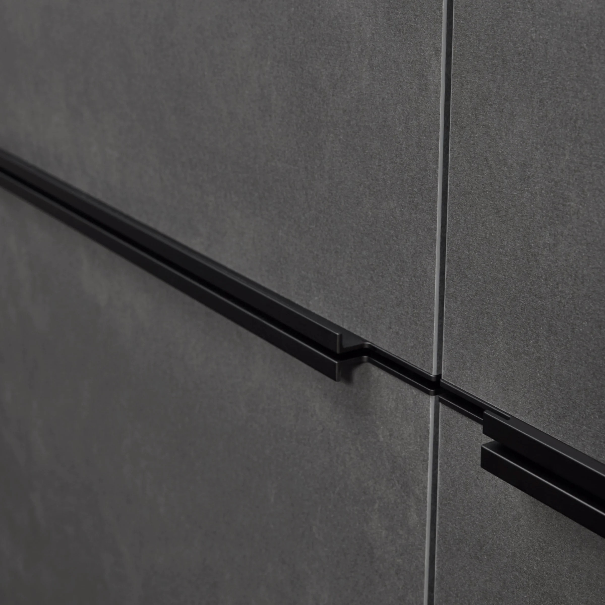 Moderne, graue Küchenschrankfronten mit schwarzen Griffen von Nolte Küchen.