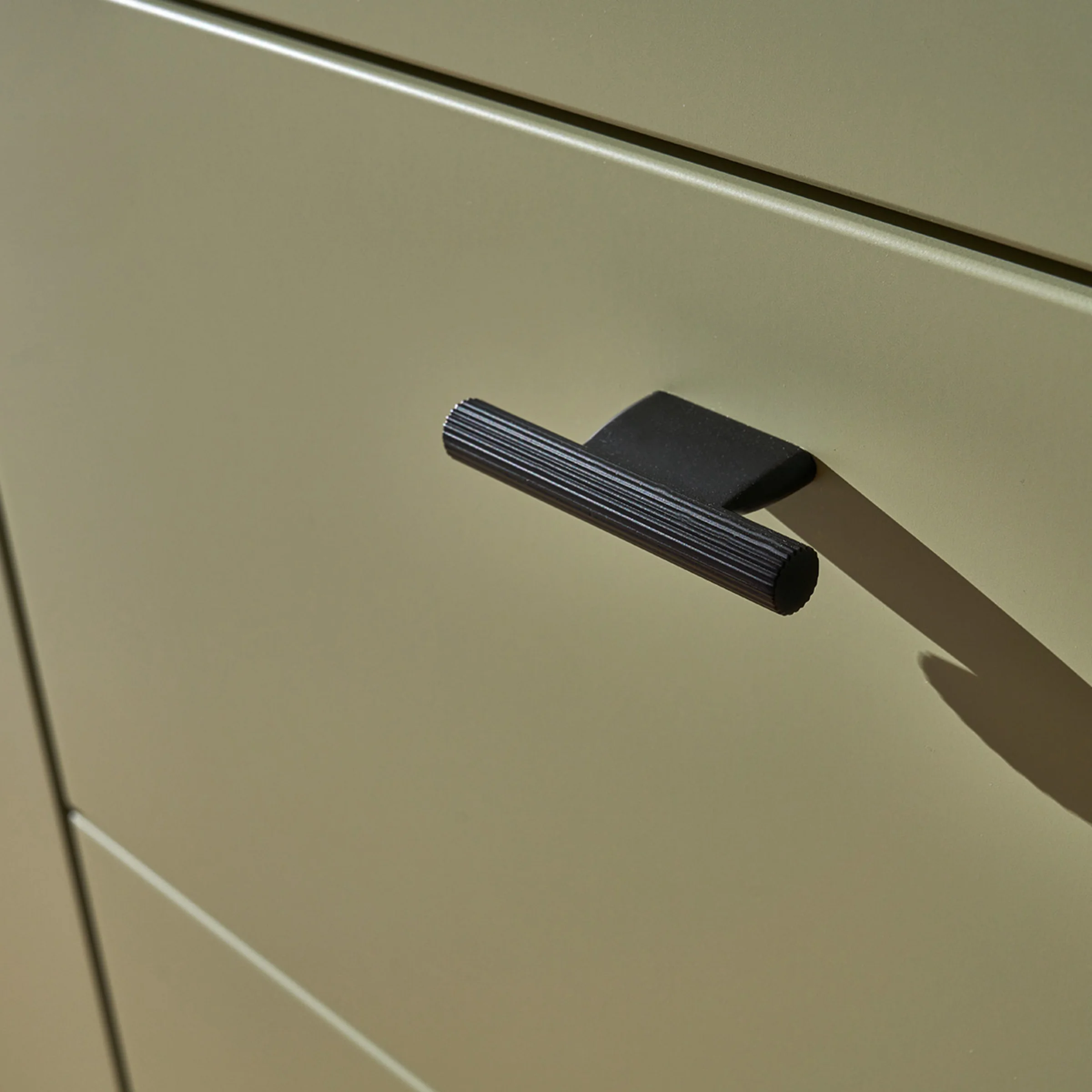 Ein grüner Küchenschrank mit einem schwarzen Griff, Teil von Nolte Küchen.