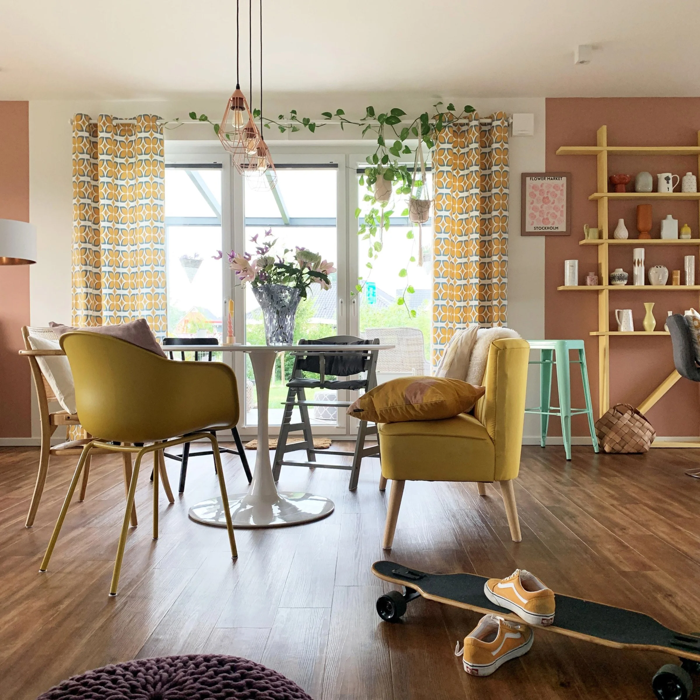 Ein modernes Wohnzimmer mit gelbem Sessel und Skateboard auf Holzboden, gestaltet von Nolte Living.