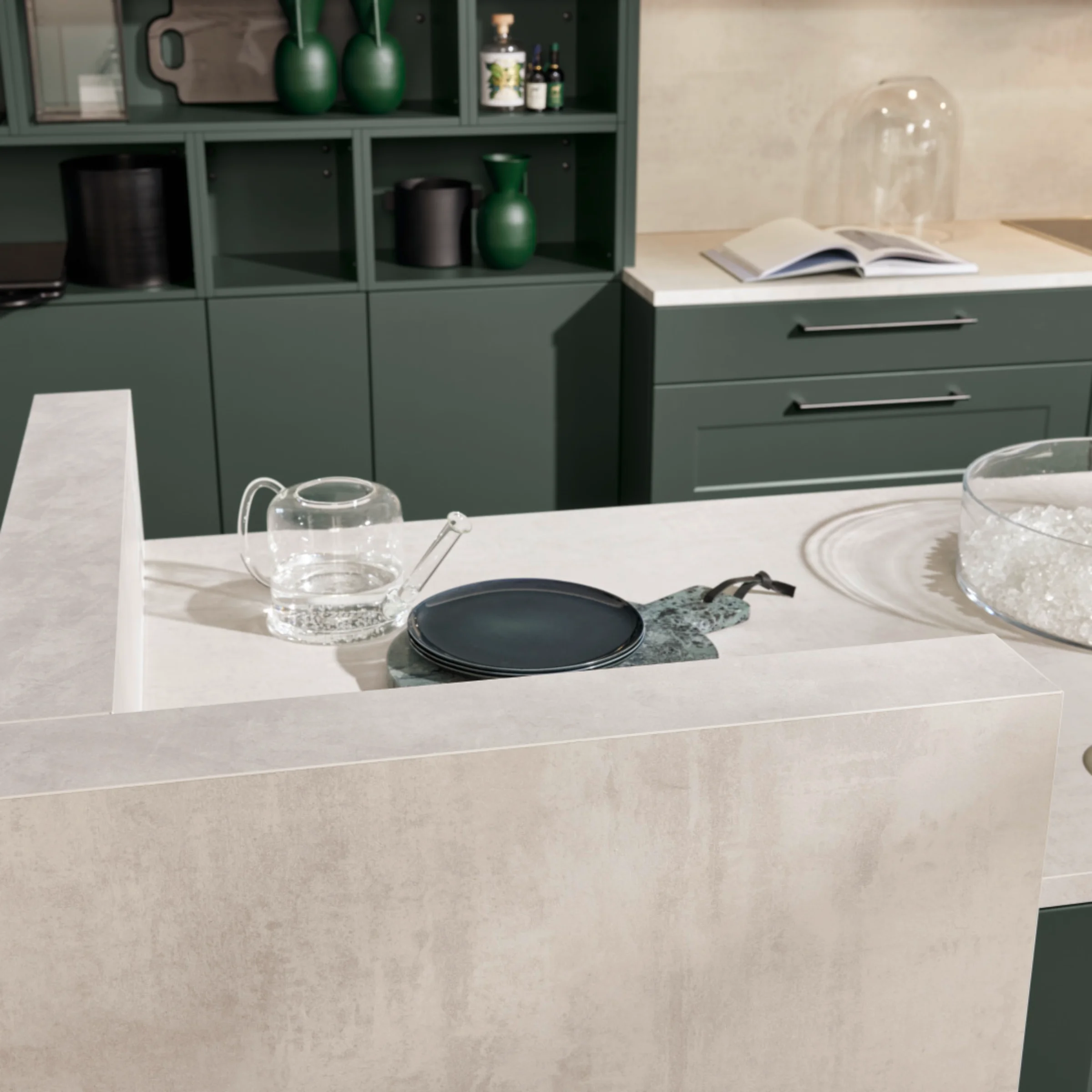 Eine moderne Küche mit grünen Schränken und weißer Arbeitsplatte von Nolte Küchen.