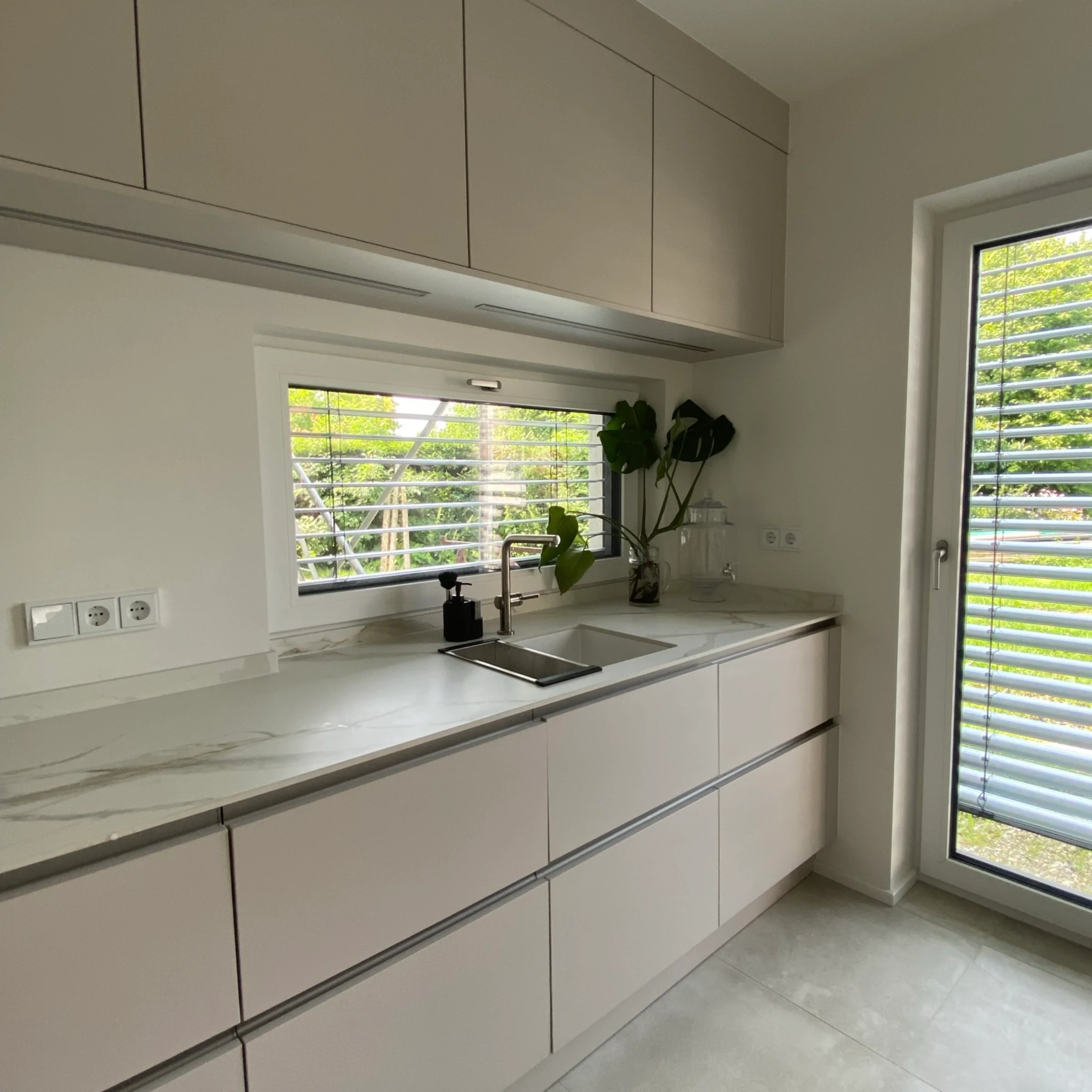 Eine moderne Küche mit elegantem Design und großen Fenstern. Nolte Küchen.