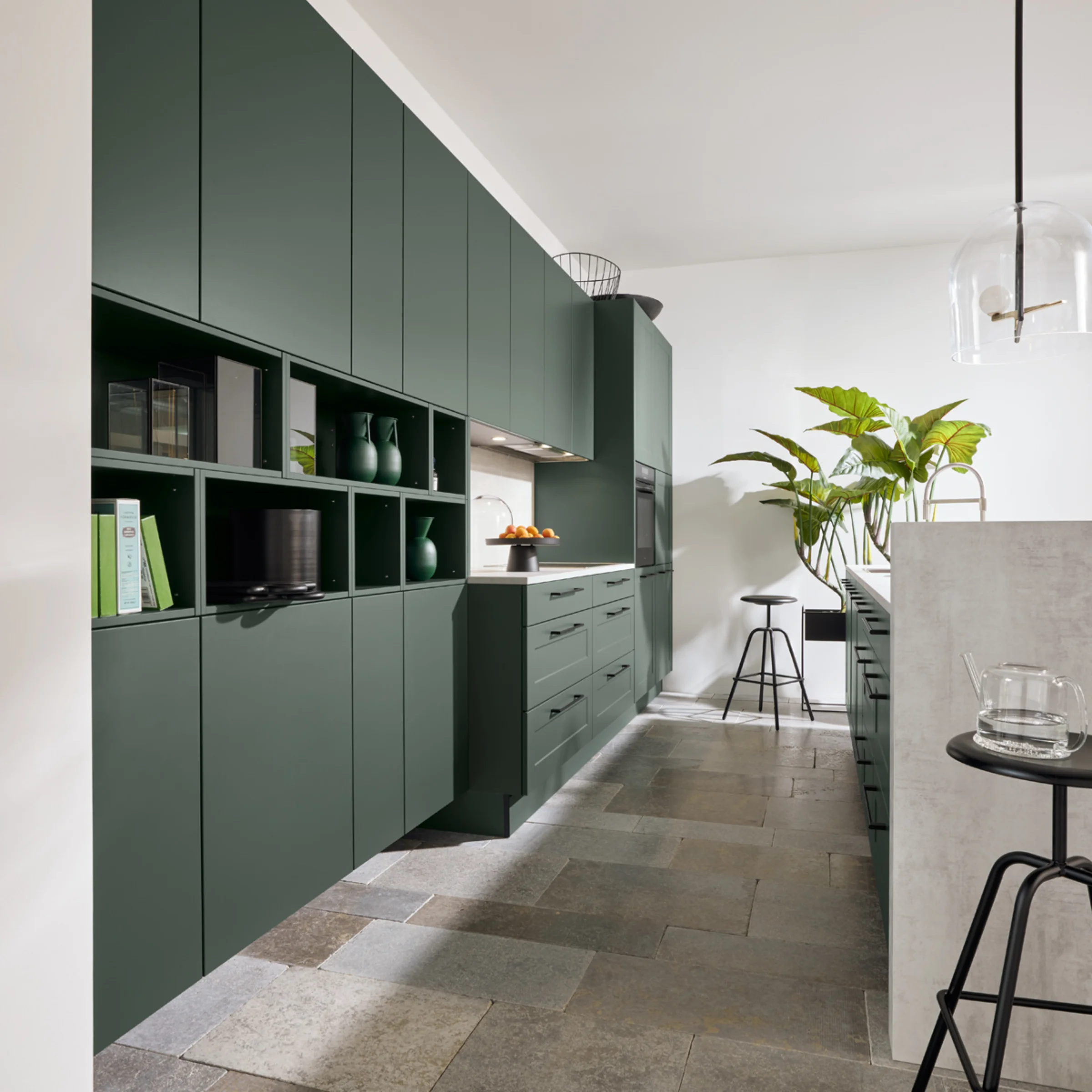 Eine moderne Küche mit grünen Schränken und Steinboden, Nolte Küchen.