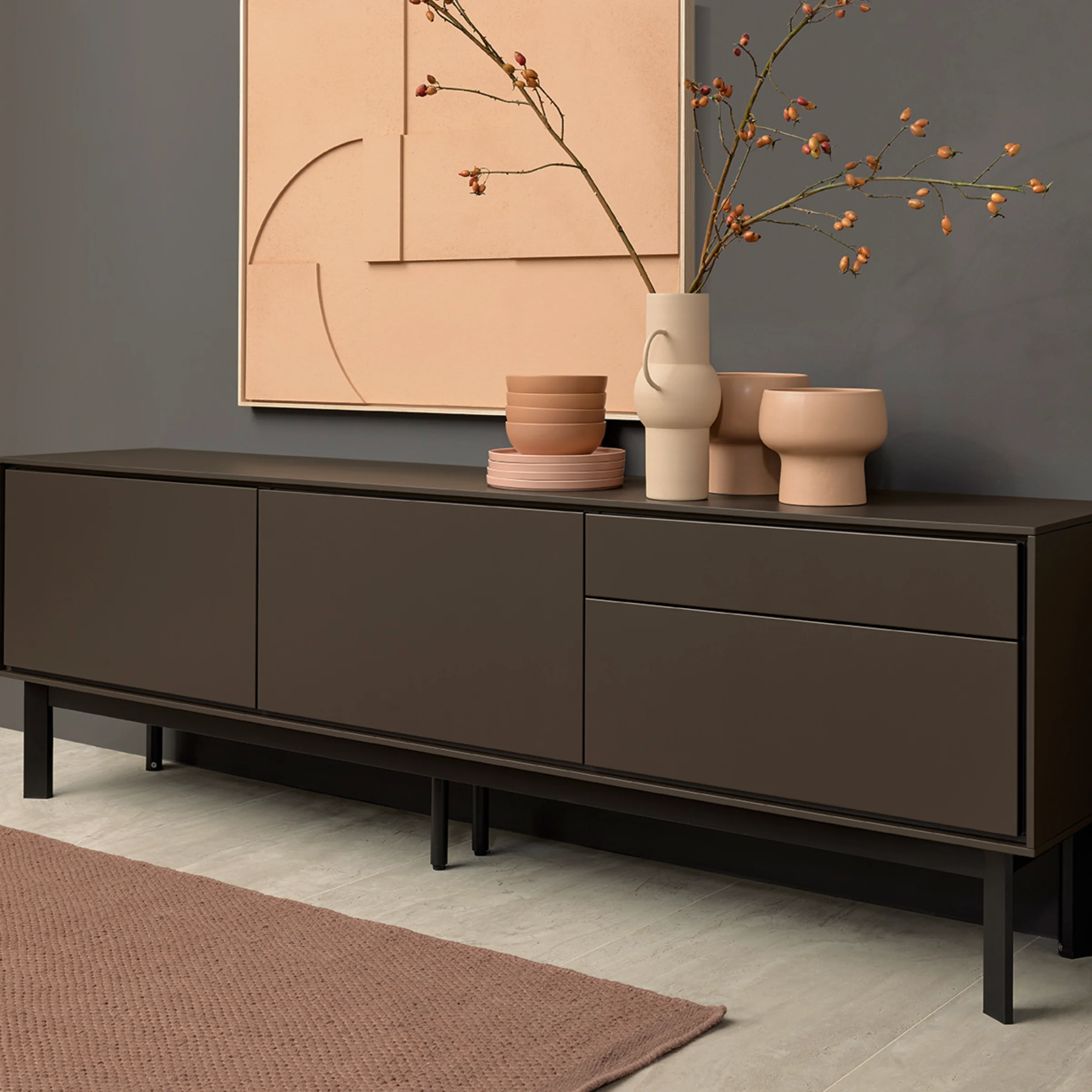 Ein modernes Sideboard mit Dekoration vor grauer Wand, passend zu Nolte Living.