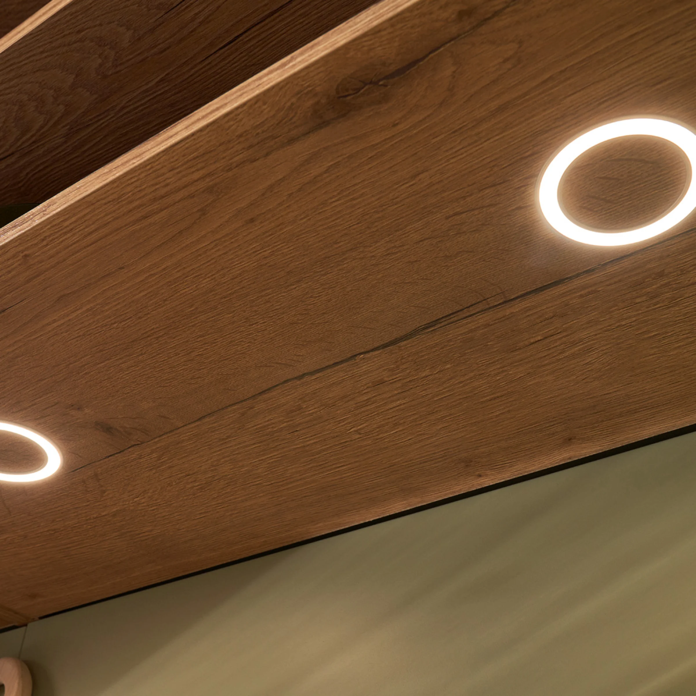Holzregal mit integrierten runden LED-Leuchten, passend zu Nolte Living Design.