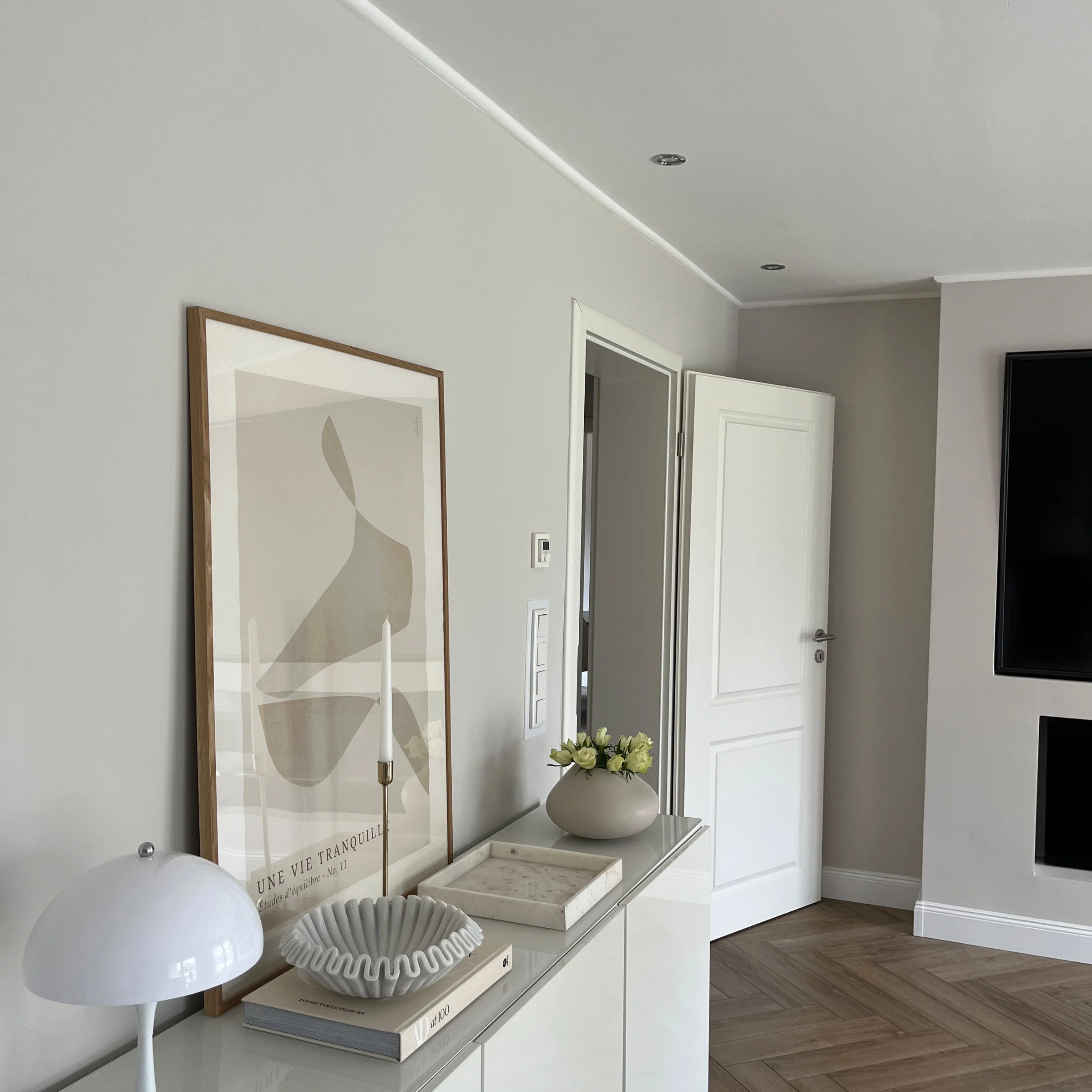 Ein modernes Wohnzimmer mit weißen Möbeln und Dekoration, präsentiert von Nolte Living.