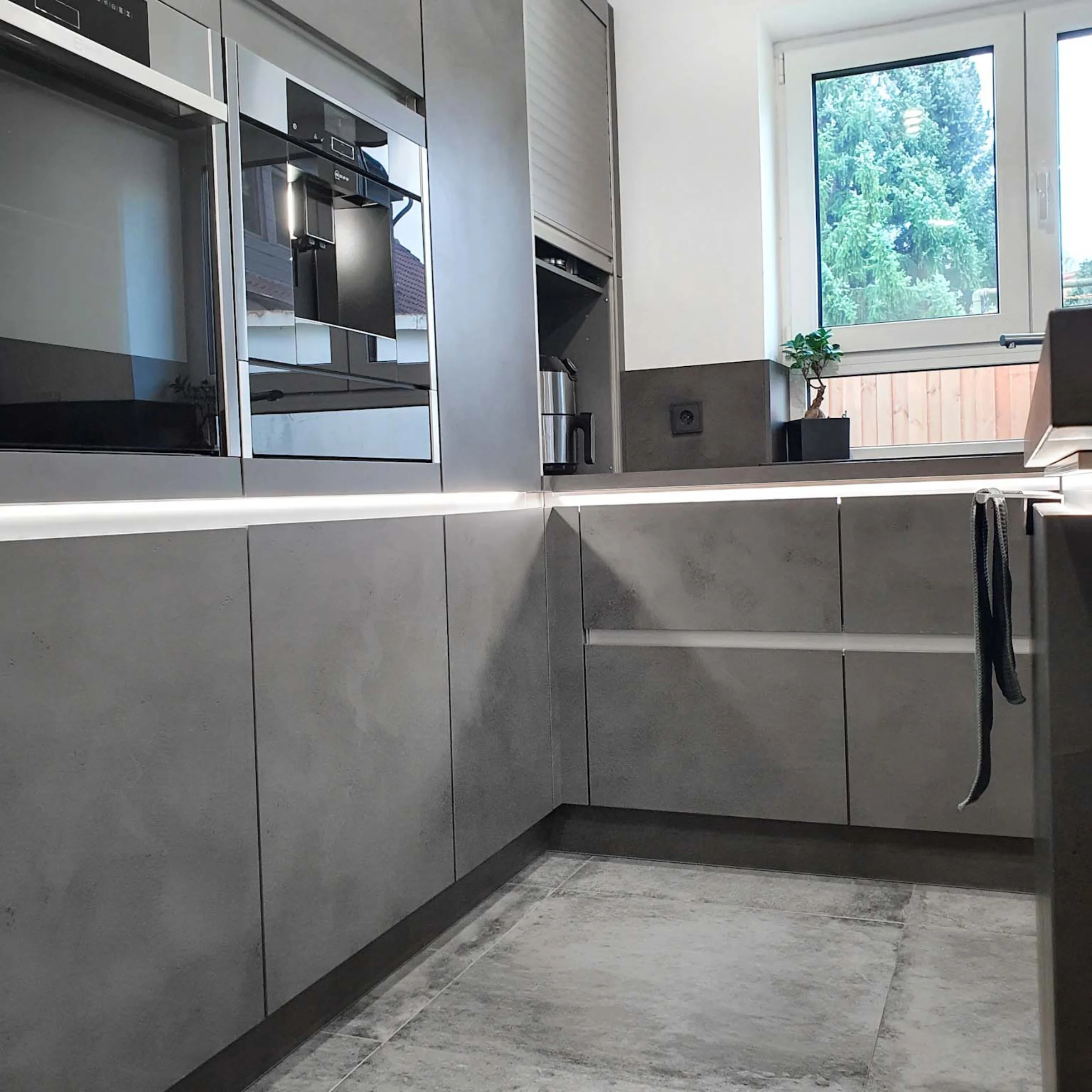 Eine moderne Küche mit grauen Schränken und Geräten, Nolte Küchen.