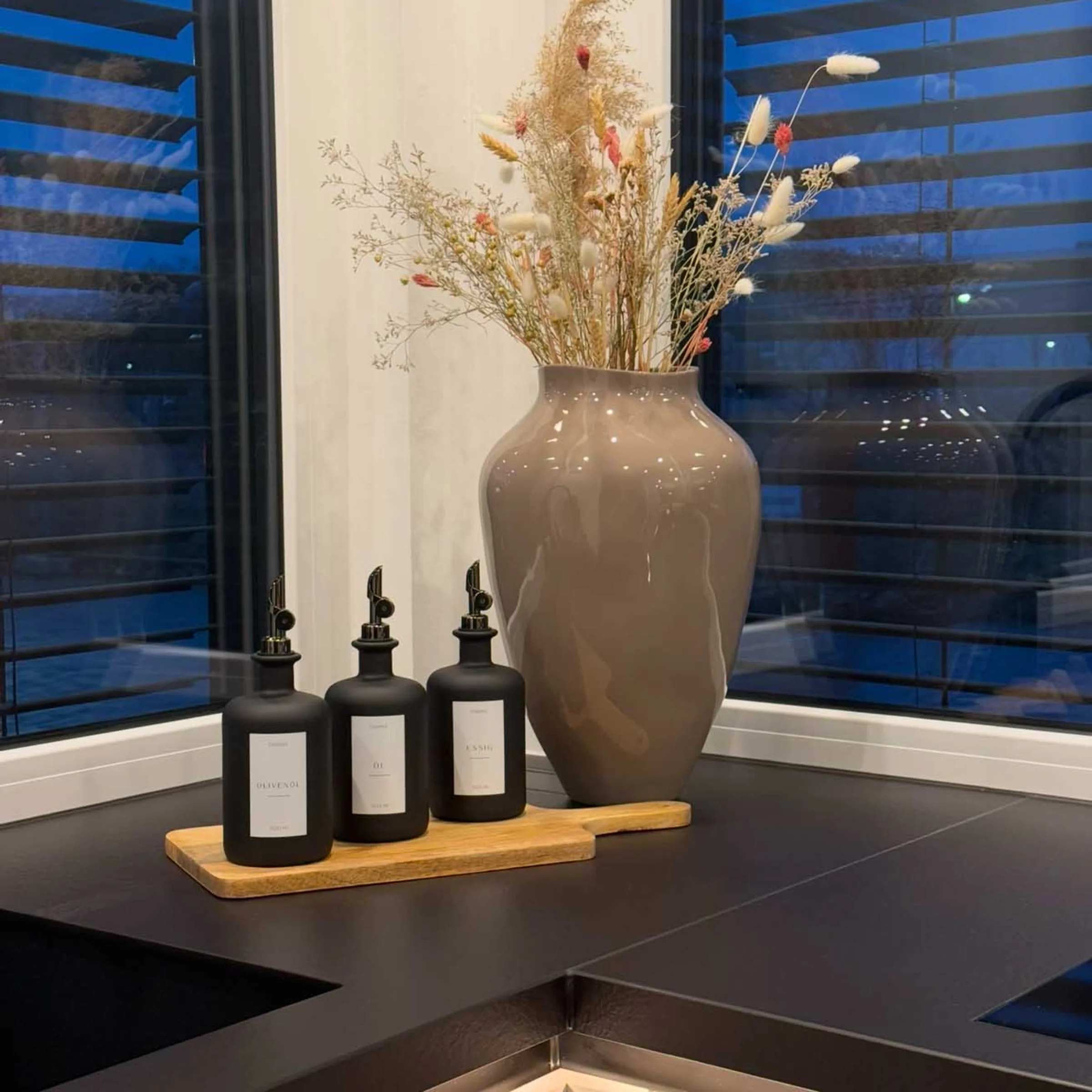 Eine stilvolle Dekoration mit Vasen und Flaschen in einer modernen Küche von Nolte Küchen.