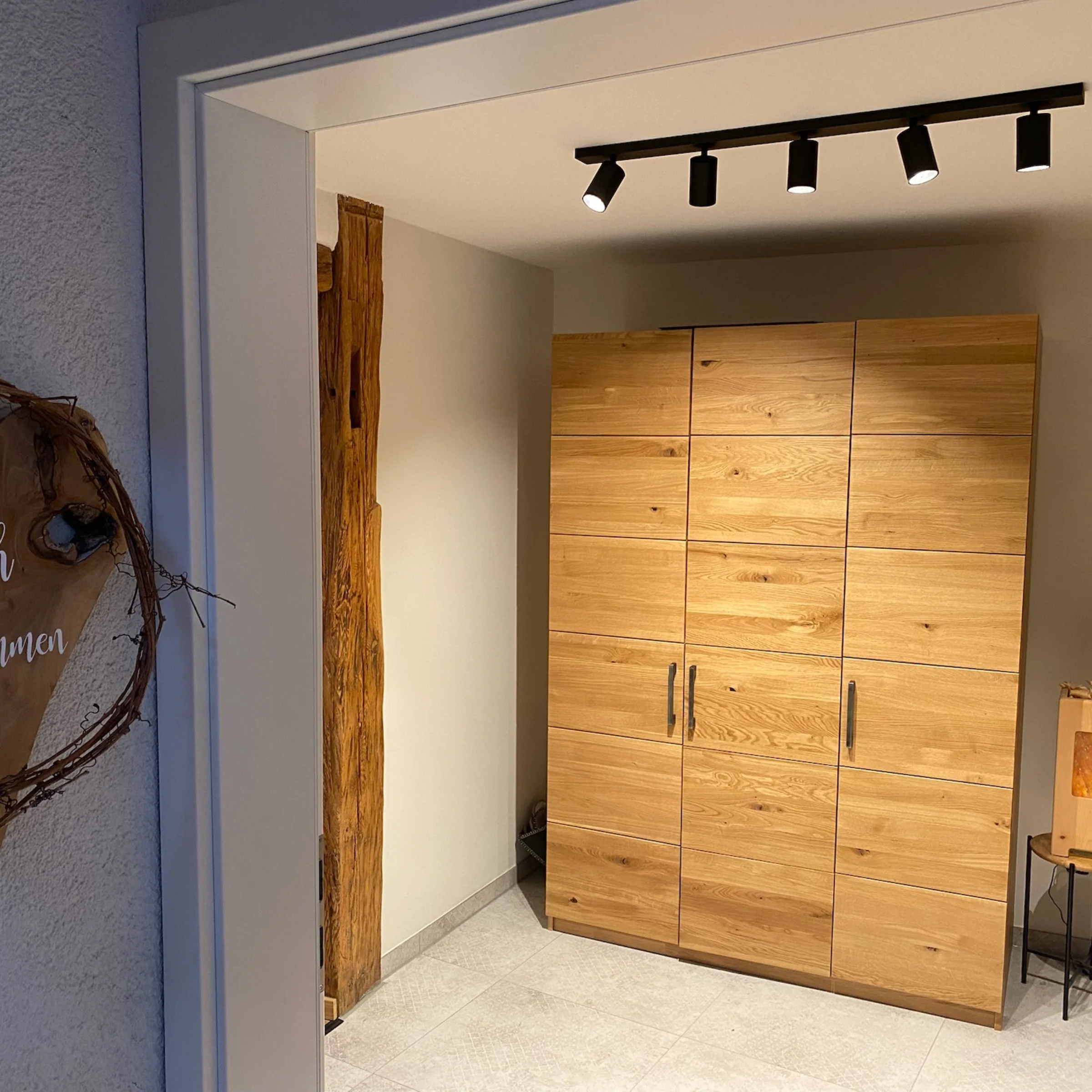 Ein Eingangsbereich mit Holzschrank und Dekoration, passend zu Nolte Living.