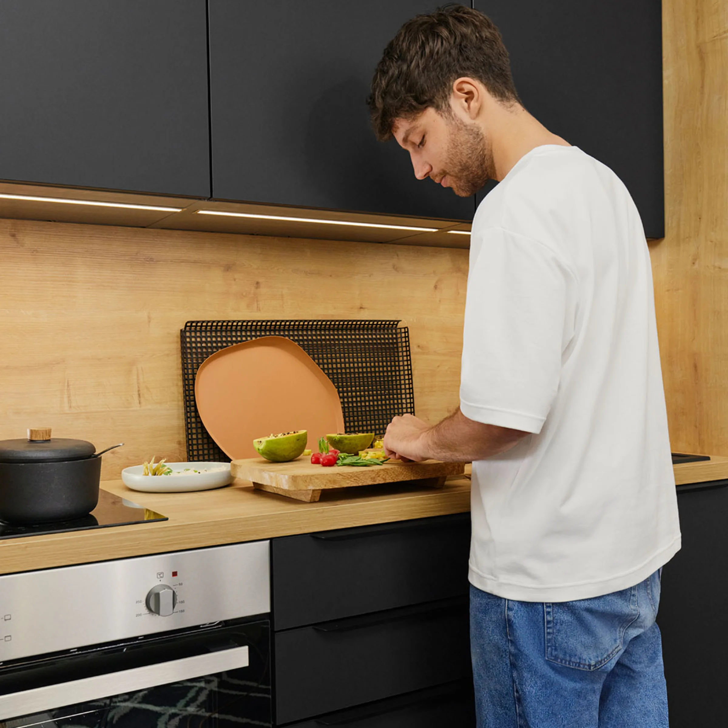 Ein Mann bereitet in einer modernen Küche Zutaten vor, umgeben von Nolte Küchen.