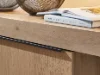 Ein Holzschrank mit Büchern und Drahtkörben darauf gehört zur Serie Nolte Living.