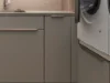 Ein moderner Hauswirtschaftsraum mit grauen Schränken und Waschmaschine, Nolte Hauswirtschaftsräume.
