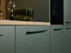 Modern kitchen cabinets with green fronts and black handles by Nolte Kitchen.