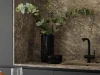 A stylish kitchen with marble look, black faucet, and green plants. Nolte Kitchen.